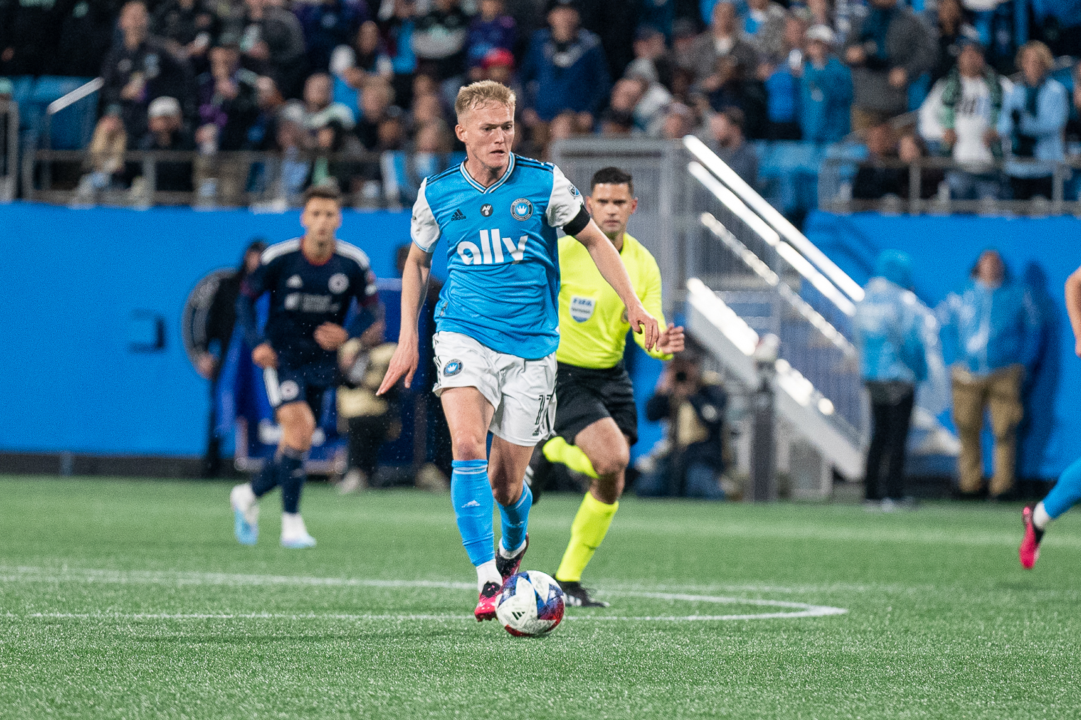 Charlotte FC striker Karol Swiderski kicks the soccer ball downfield at Bank of America Stadium against New England Revolution