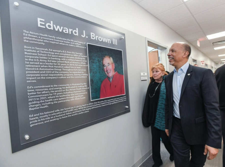 Advocate Health CEO Gene Woods walks looks at a plaque of Charlotte business leader Ed Brown at the West Boulevard community center named for him. 