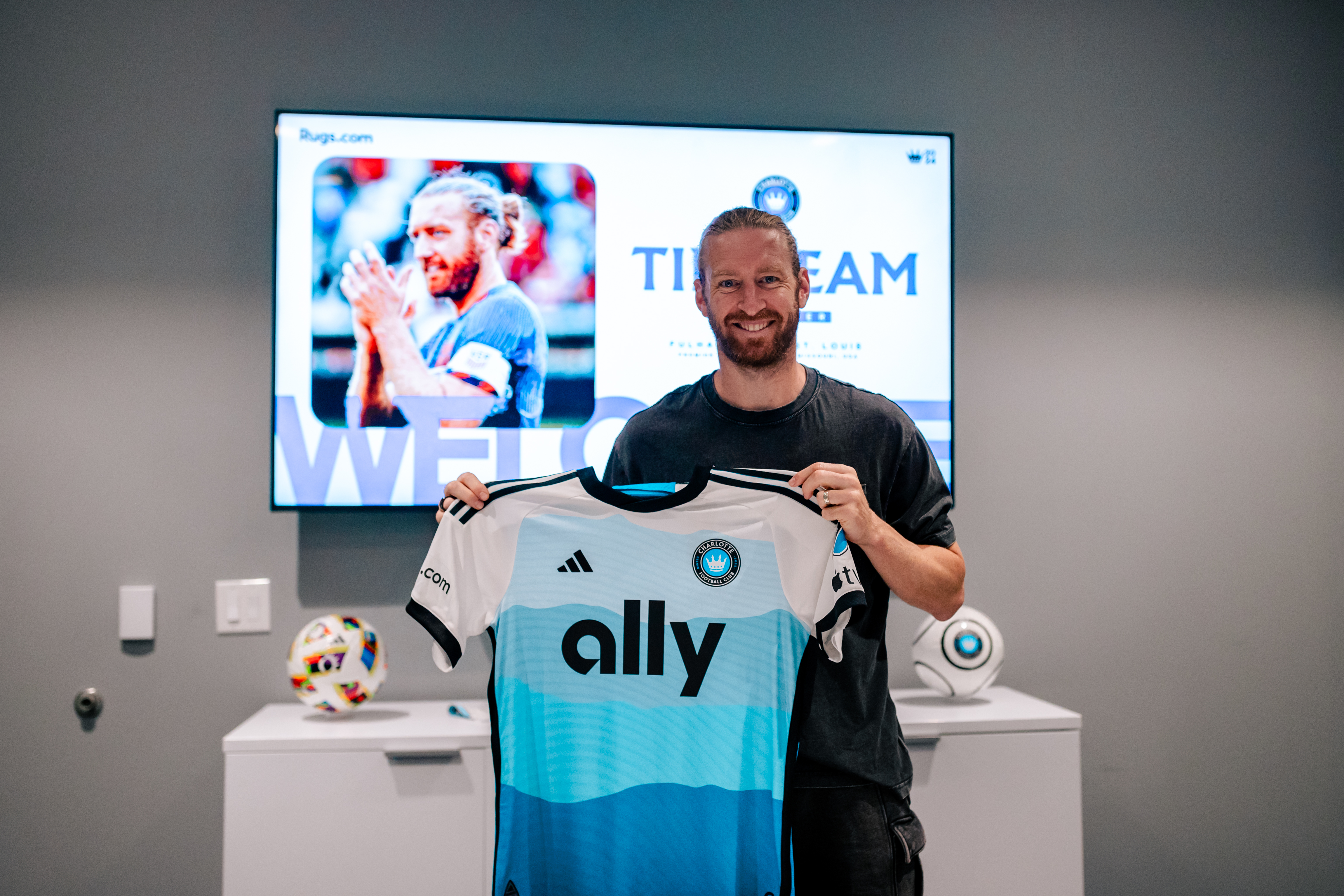 Tim Ream shows off his Charlotte FC jersey after signing a contract