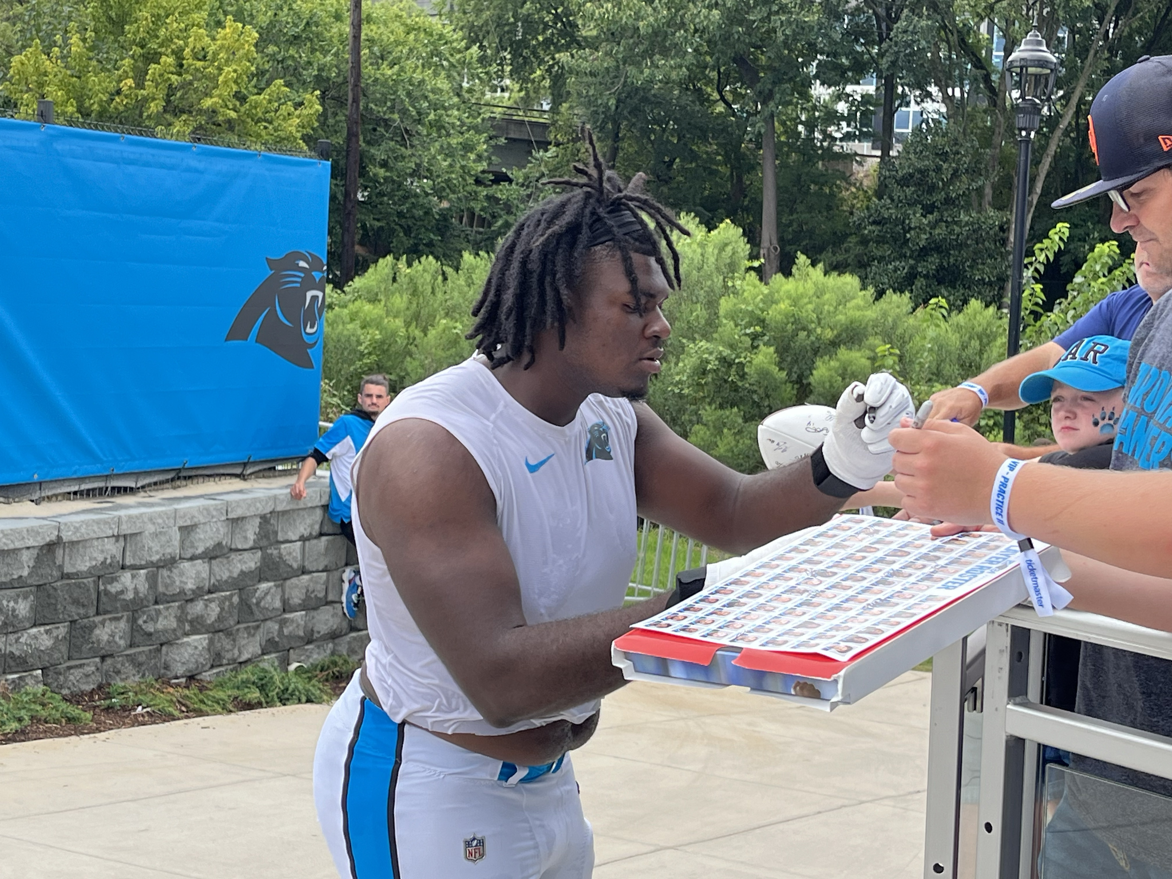Carolina Panthers tackle Ricky Lee signs a fan's poster