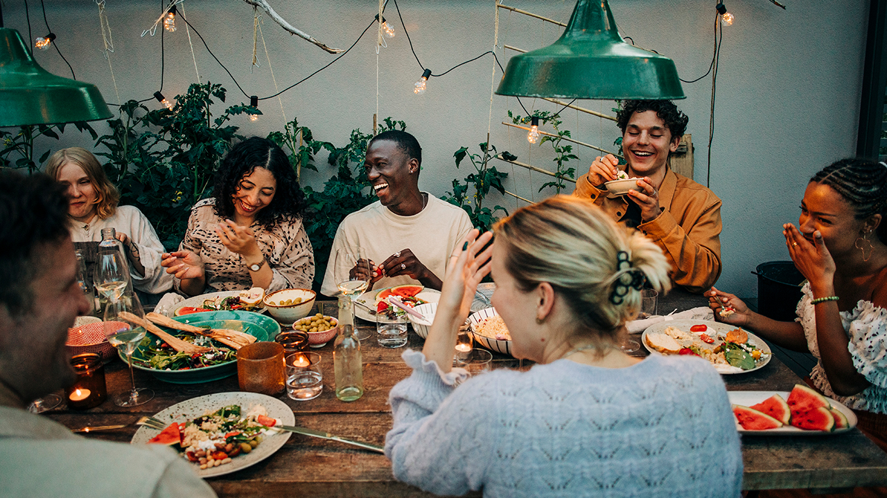 People gather around a table for a meal and conversation